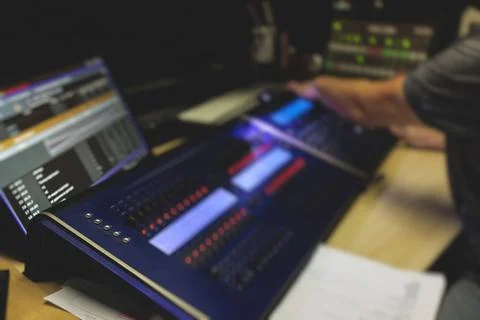 View of lighting technician operator working on mixing console workplace duri Stock Photos