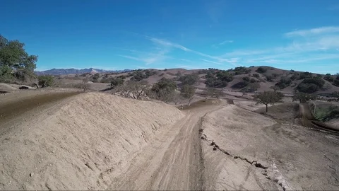 View of a line of bikers approaching a jump on a desert race track Stock-Footage 92107039