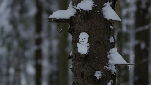 View of a little snowman through the falling snow, slow motion Stock Footage 70455293