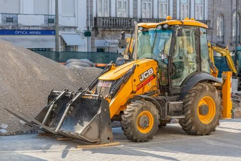View of a loader tractor standing next to a pile of earth at the construction Stock Photos