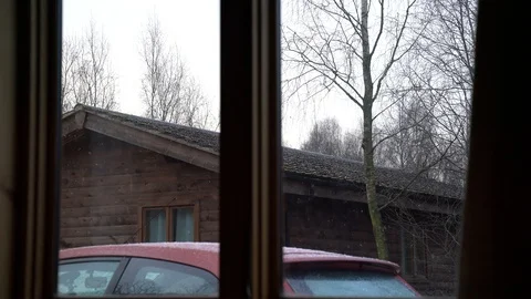 View from log cabin with snow falling on red car with chalet in the background Video stock 86488143