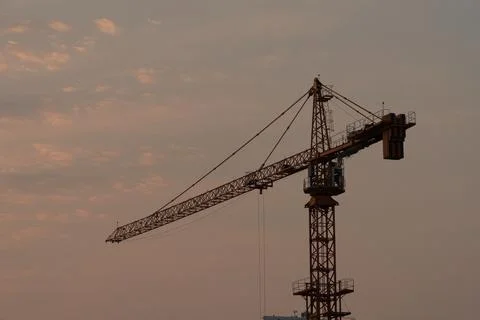 View of a lone tower crane at sunset Stock Photos