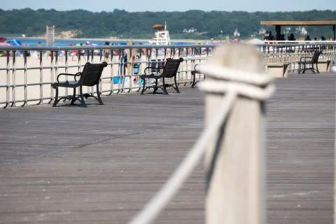 View looking down a beach boardwalk past rope post shallow depth of field tow Stock Photos