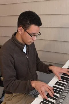 View looking down at a young man playing an electric keyboard Stock Photos