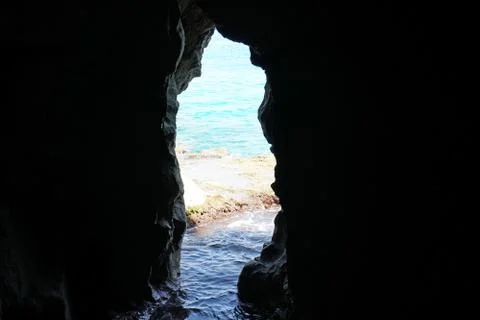 View looking inside of a natural sea cave with a view of the sea at the back Stock Photos