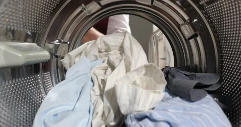 View Looking from the inside Washing machine As the businessman's hands load, Stock-Footage 152855792