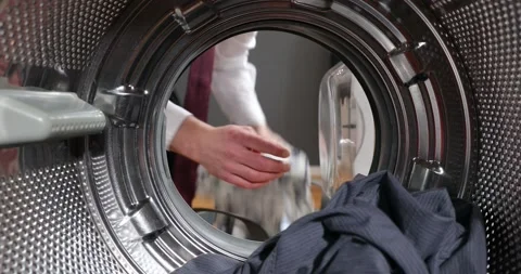 View Looking from the inside Washing machine As the businessman's hands load, Stock Footage 152855845