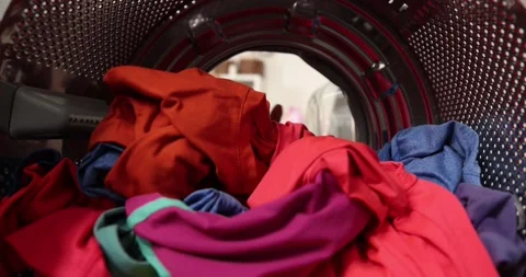 View looking from inside washing machine, man takes out laundry Stock Footage 178560404