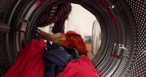 View looking from inside washing machine, man takes out laundry Stock Footage 178568893