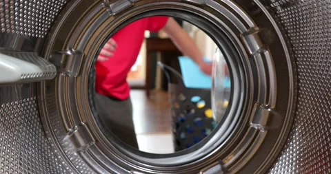View Looking Out From Inside Washing Machine As boy Puts In Laundry Load. A y Stock Footage 152857864
