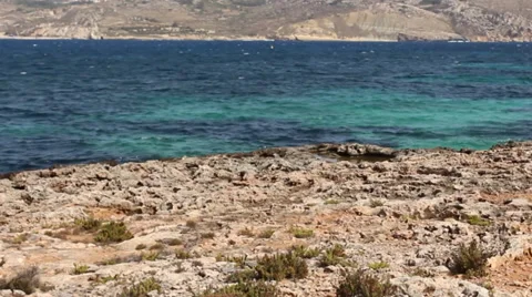 View Looking Over Rocks Foreground And Clear Blue Sea Waves Video stock 37230882