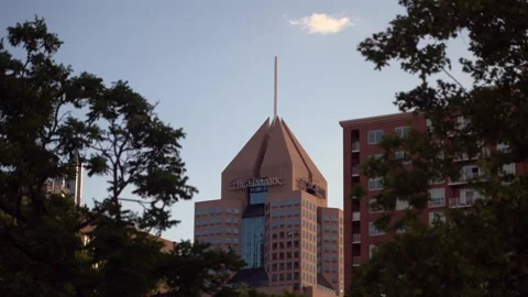 View looking toward a building peak and architectural structure behind trees in Stock Footage 342220086