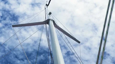 View from lower angle of mast of sailboat against the blue sky and white clouds. Stock Footage 136429150