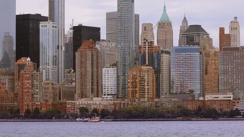 View of lower Manhattan with ferry boat passing by as seen from New York Harbor. Stock Footage