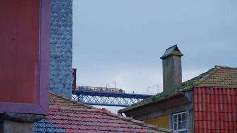View of Luis I bridge in Porto as yellow metro light rail train passes by Stock Footage 293495142