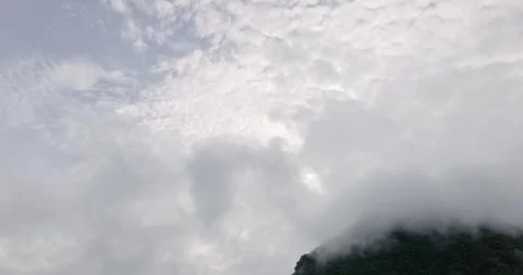 View of a lush green mountain peak partially shrouded in soft. Stock Footage 314660970