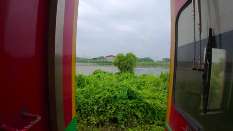 View of lush vegetation and a distant building from a train, Thailand. Stock Footage 339952682