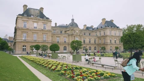 View of the Luxembourg Palace, spring Primula beds and tourists. Stock Footage 308734269