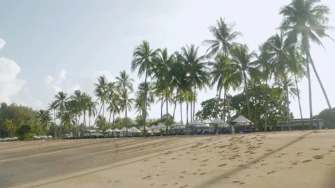 View of the luxury beach lounge beds with umbrella on white sand beach from t Stock Footage 202129183