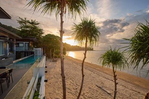 View from luxury villa at sunset, pool lighting, sun loungers for sunbathing 写真素材