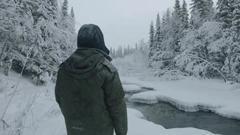 View of a man from the back on the river bank in the winter forest. Calm and 库存影片 157095950