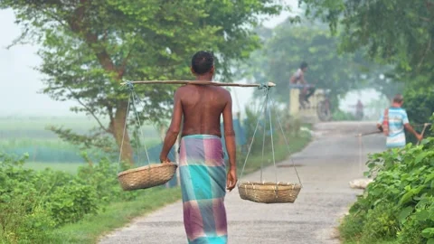 View of a man carrying baskets on a yoke, Bangladesh. Video stock 334975730
