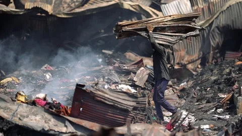 View of a man carrying debris through a fire-damaged area, Bangladesh. 動画素材 335600211