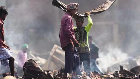 View of a man carrying debris through smoke in Dhaka, Bangladesh. Stock Footage 335600294