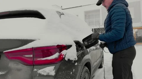 View of a man connecting a charging cable to an electric car charging station. Stock Footage 167437717