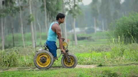 View of a man with a disability riding a custom tricycle, Bangladesh. Video stock 334971609