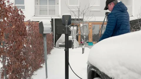 View of a man folding a charging cable from an electric car charging station. Stock Footage 167667927