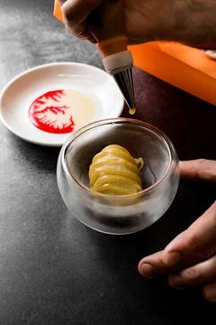 View of man hands decorating molecular cuisine dessert dish with sweet jam Stock-Fotos