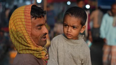 View of a man holding a young child at a night market, Bangladesh. Vídeo Stock 335600060