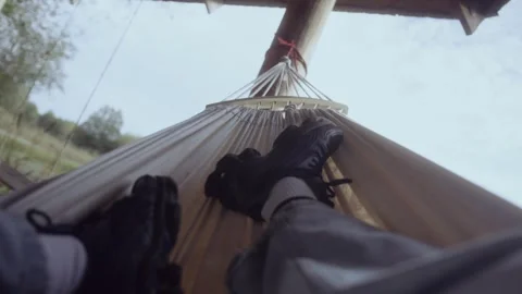 View of man legs swinging on hammock. POV Stock Footage 286094709