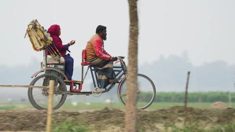 View of a man pedaling a cycle rickshaw in Bogura, Bangladesh. Video stock 334971837