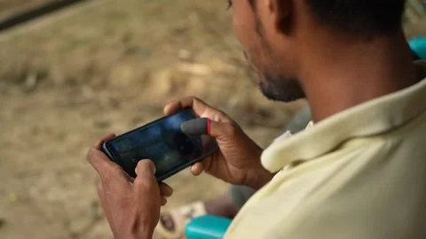 View of a man playing a mobile game with finger sleeves, Bangladesh. 스톡 동영상 335025182