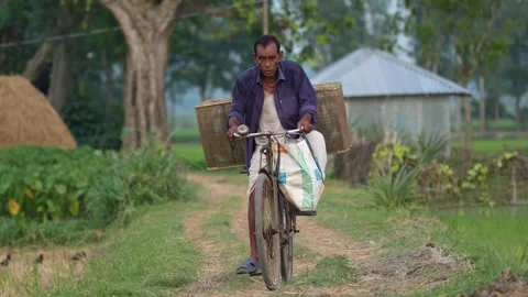 View of a man riding a bicycle with crates, Bangladesh. Video stock 334976067