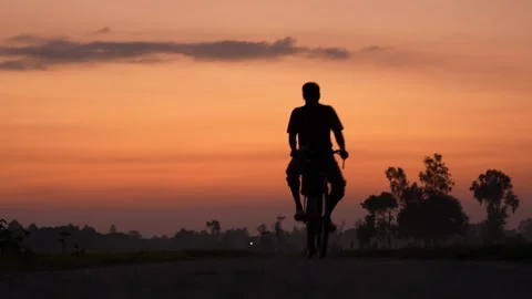 View of a man riding a bicycle at sunset in Bogura, Bangladesh. Stock Footage 335552731