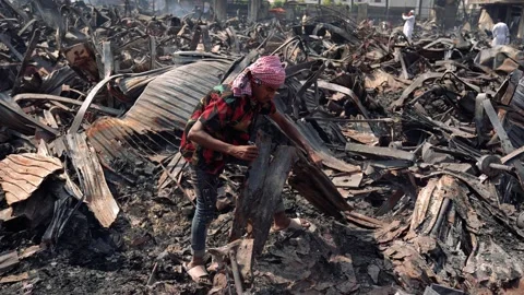 View of a man searching through charred debris after a fire, Bangladesh. Vídeo Stock 335600162