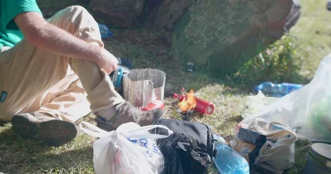 View of a man sitting on the ground camping Stock Footage 108493500