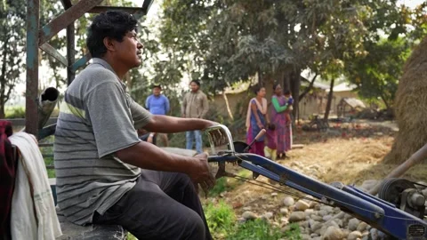 View of a man sitting on a power tiller in a rural village, Nepal. Stock Footage 335471527