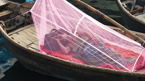 View of a man sleeping under a mosquito net on a boat, Bangladesh. Stock-Footage 335600392
