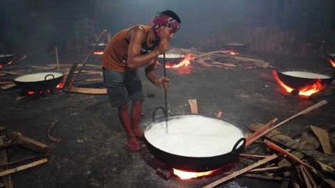 View of a man stirring milk over an open fire in Bangladesh. Stock Footage 336425684