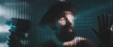 View of man through shaped clear panel in blue lights Stock Footage 203569388