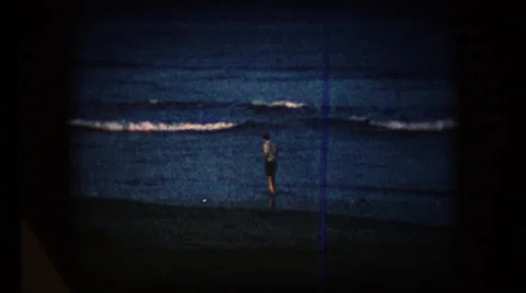View of a man walking along the beach in the mid 1960's Stock Footage 58221551