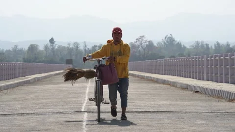 View of a man walking with a bicycle on a bridge, Nepal. Video stock 335476064