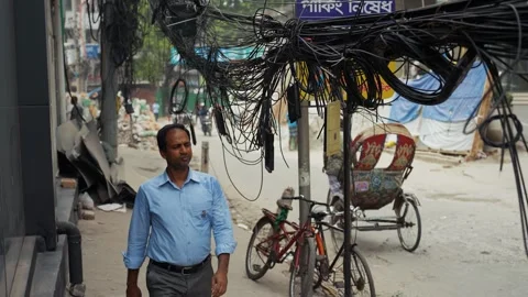 View of a man walking under tangled wires in Dhaka, Bangladesh. 스톡 동영상 335557073
