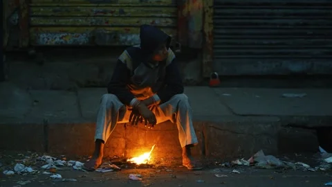 View of a man warming himself by a fire at night in Bogura, Bangladesh. Video stock 335551137