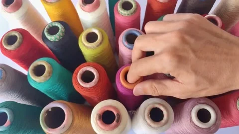 View of a man's hand picking up a spool of Thread Stock Footage 225182605