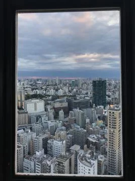 View of many modern buildings and blue sky from the window frame Stock Photos